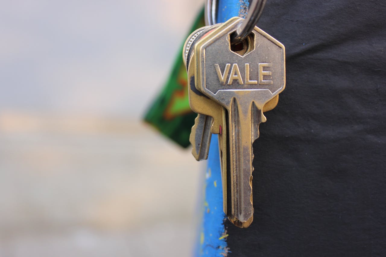 Services A detailed view of a metallic key with 'Vale' engraved on it, hanging against a blurred background.